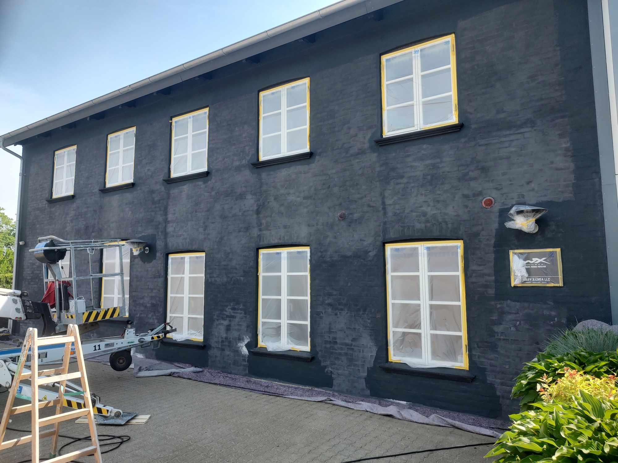 Sort hus males med hvide vinduer