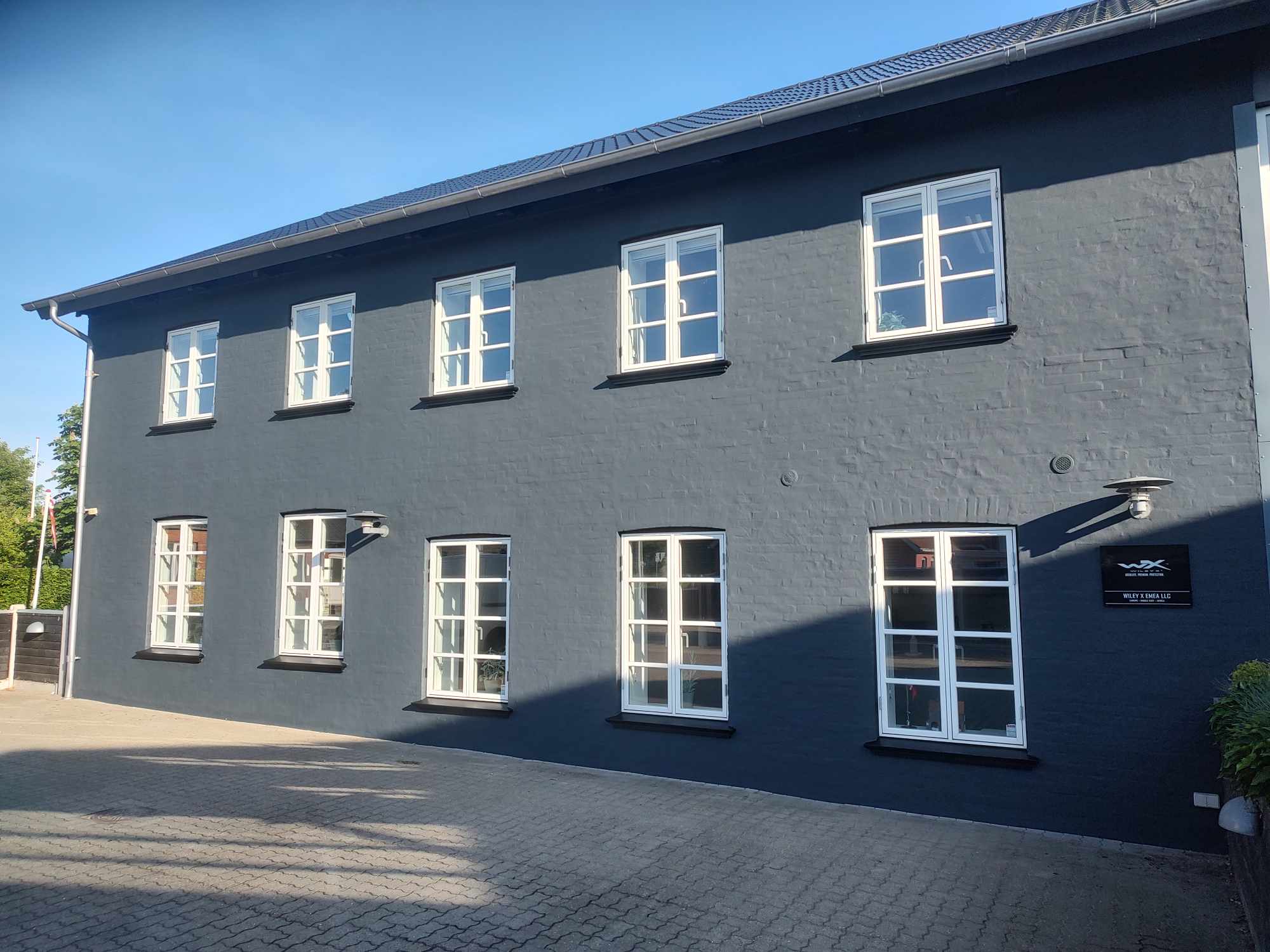 Mørkegrå kontorbygning med mange vinduer