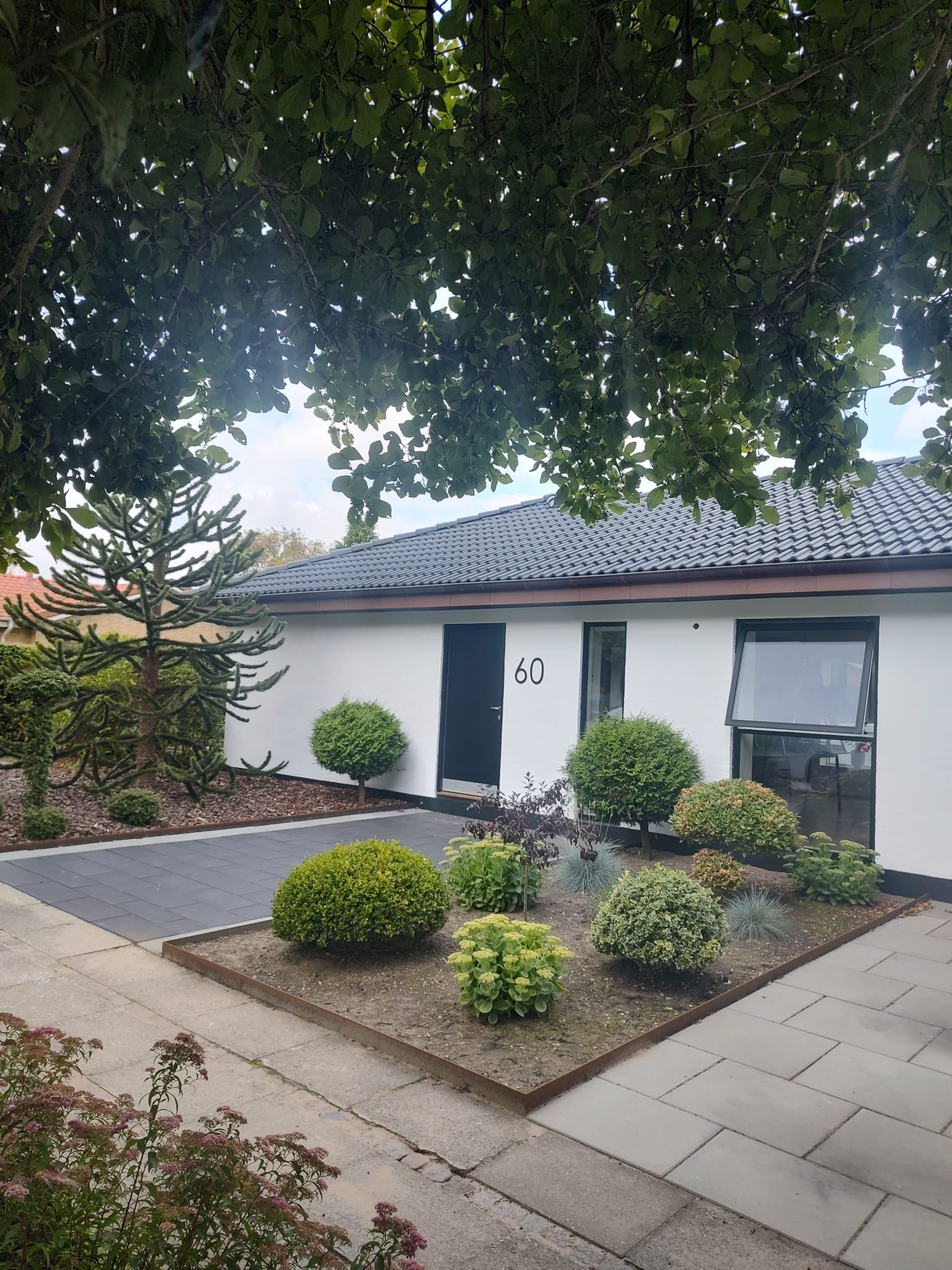 Moderne hvidt hus med velplejet forhave
